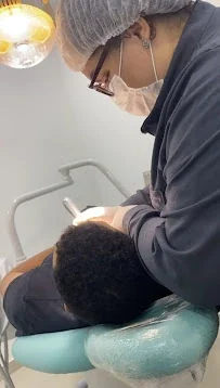Profissional realizando atendimento odontológico na clínica